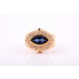 A gold plated reproduction dress ring with a central synthetic blue marquise cut stone surrounded by