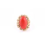 A 1970’s Continental gold and coral cabochon ring, the oval cabochon approximately 21.5mm x 13mm,
