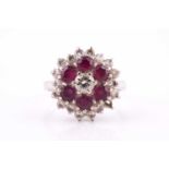 An 18ct white gold, ruby and diamond flower-head cluster ring, centred with a small round