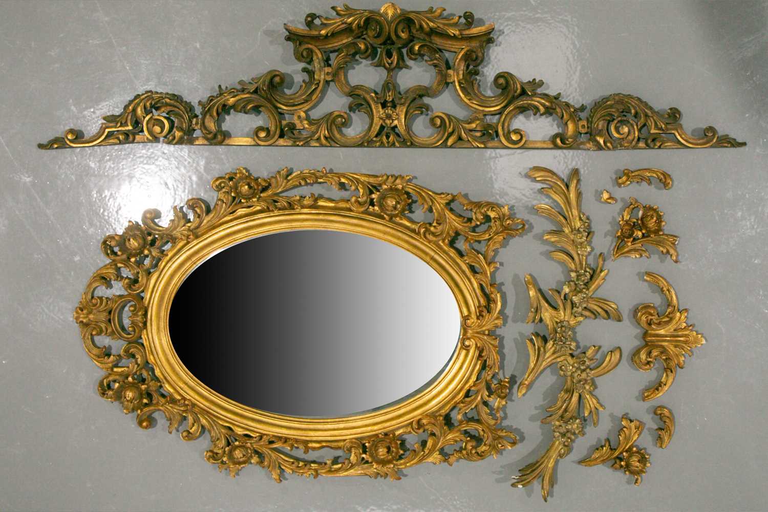 A 19th-century Venetian style carved, pierced wood oval wall mirror with florid scrolling frame,