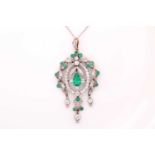 An Edwardian emerald and diamond pendant, of openwork cartouche design, centred by a pear shape