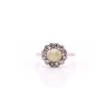 A white metal cluster ring stamped platinum, consisting of a central cabochon 'cats eye' chrysoberyl
