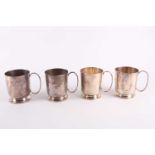 A set of four white metal tankards each with a loop handle and flared foot, all engraved with a