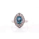 An art deco style aquamarine and diamond cluster ring on white metal stamped platinum, consisting of