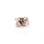 A yellow metal stamped 18ct diamond set ring, consisting of two claw set with round brilliant cut