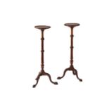A pair of George III style mahogany torcheres,20th century, with turned and fluted columns, upon