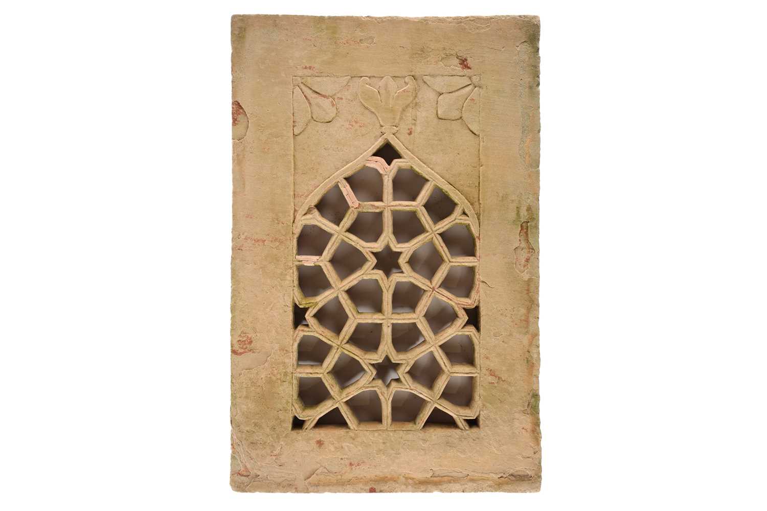 An Indian carved and pierced lancet arched pottery window panel of cellular design with a central