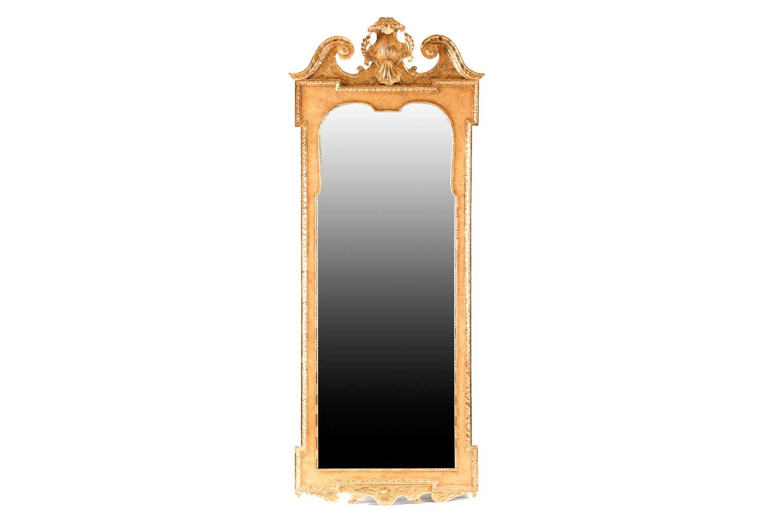 A Queen Anne carved wood and gilt gesso pier mirror with swan neck pediment and leafy mantle above a