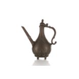 An Indian Mughal brass ewer (Aftaba), 18th century or later, with hinged domed finial with pointed