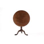 A George III circular mahogany snap top wine table with birdcage movement, a half fluted and