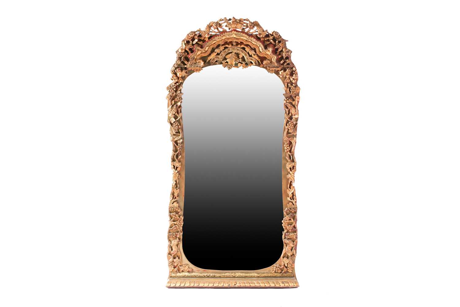 A Chinese carved pierced and giltwood wall mirror of hipped arched form, 20th century, decorated