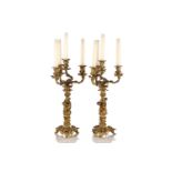 A pair of gilt bronze four sconce figural candelabra of rococo form. Each column is cast with