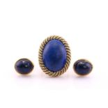 A lapis lazuli dress ring, the oval lapis cabochon within a wrythen ropetwist surround, to thick