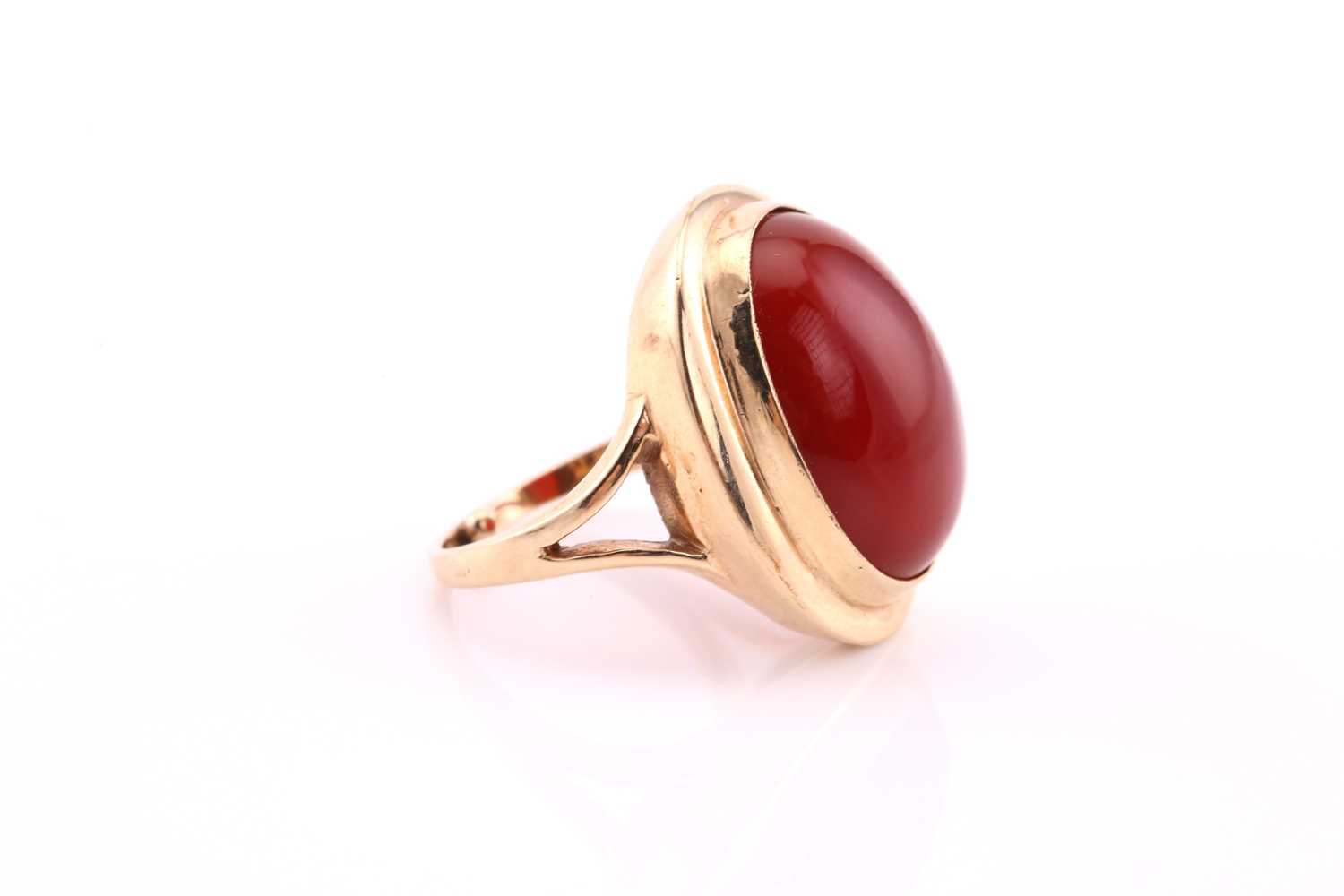 A carnelian cabochon ring, mid 20th century, the 19 x 14.5mm oval cabochon collet set to a yellow - Image 3 of 4