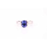 A single stone tanzanite ring; oval cut in four claw mount to a plain D section platinum shank.
