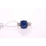 A sapphire and diamond three stone ring, the cushion mixed cut sapphire 4.21 carats, flanked two