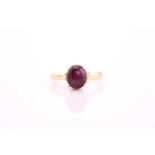 A star ruby ring, the oval 7.7 by 6.5 by 5.3mm cabochon in pinkish-purple, claw set to a yellow