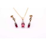 A ruby and diamond pendant and matching earrings, the pendant with an oval cut ruby surmounted by