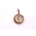 A Victorian locket pendant, the round frame surrounded with seed pearls enclosing a tinted