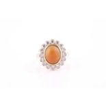 An opal and diamond cluster ring of bi-coloured design, the oval cabochon opal within a scalloped