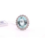 An aquamarine and diamond cluster ring, the oval mixed cut aquamarine, 13.40carats, surrounded by