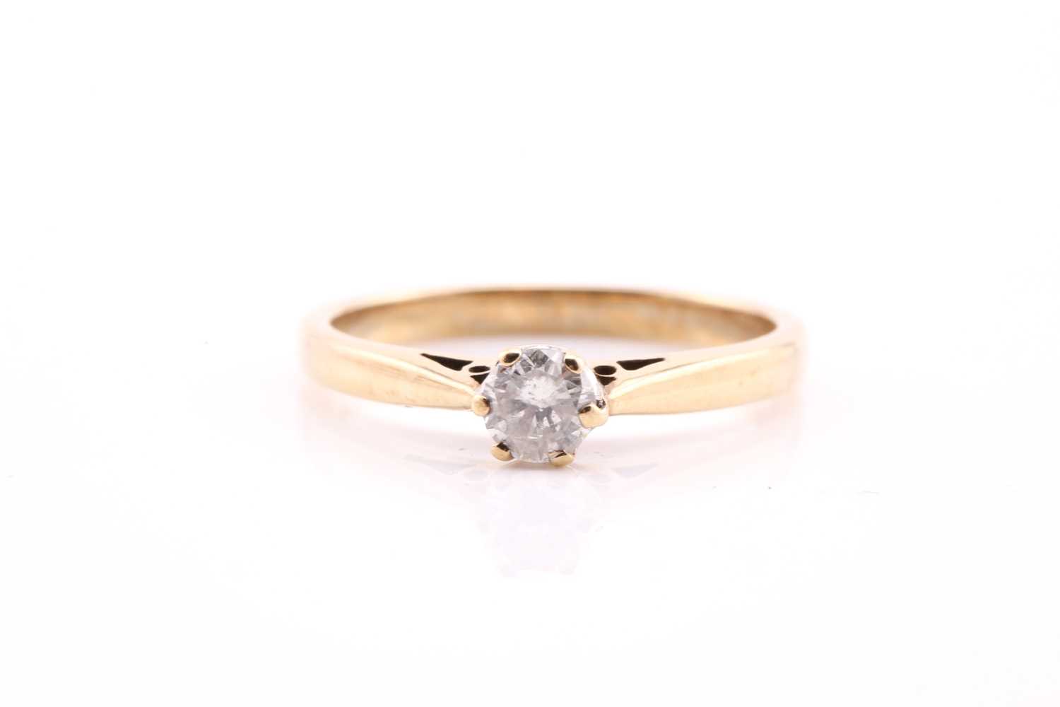 A single stone diamond ring; the round brilliant cut diamond in six claw mount to a plain 9 carat