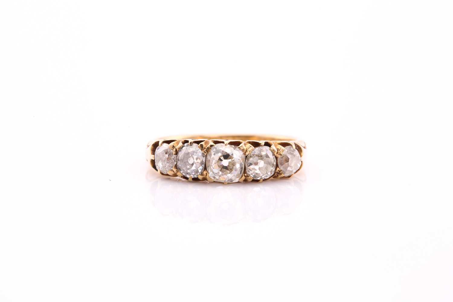 A five stone half hoop diamond ring; the graduated, mixed old cut diamonds claw set within carved