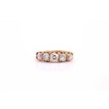 A five stone half hoop diamond ring; the graduated, mixed old cut diamonds claw set within carved