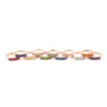 A collection of gem-set rings Each set with five circular-cut gems such as garnet, fire opal,