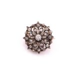 A Victorian old cut diamond set brooch/pendant, consisting of a central old cut diamond of an