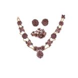 An early 19th century garnet parure, including a long necklace set with alternating floriate