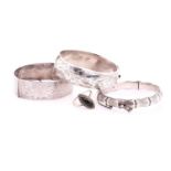 Three silver hinged bangles and a white metal ring, the hallmarked bangles each with a safety