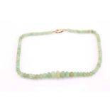 A carved bead emerald necklace, the graduated reeded beads approximately 13mm to 5.4mm, 189.00cts,