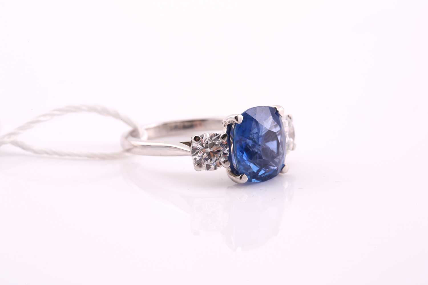 A sapphire and diamond three stone ring, the cushion mixed cut sapphire 4.21 carats, flanked two - Image 2 of 12