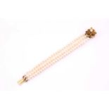 A cultured pearl and gem-set bracelet; the three-row cultured pearl bracelet to a triple flower head