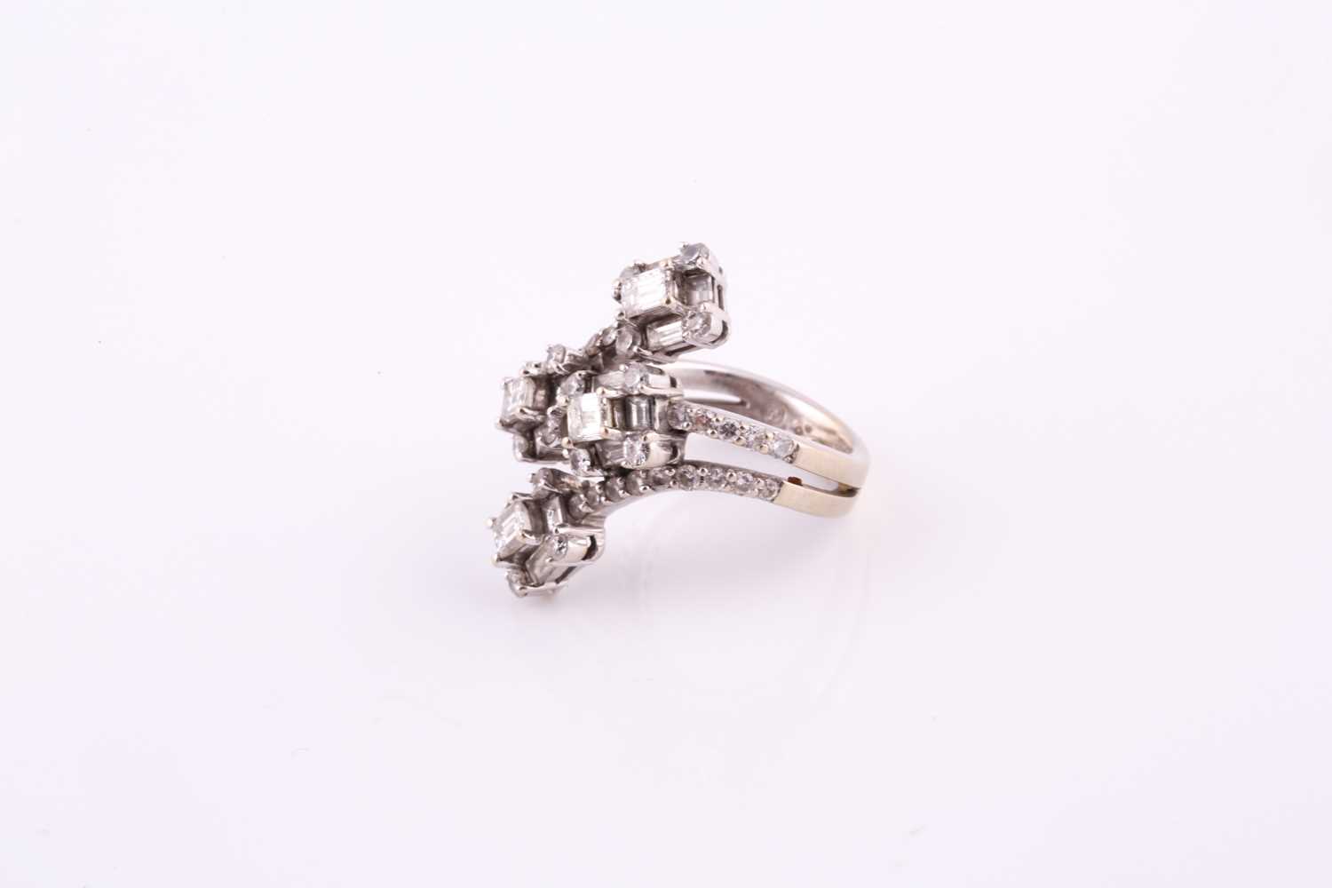 A diamond dress ring Of bifurcated design, obliquely-set to the front with four clusters of baguette - Image 2 of 6