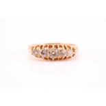An Edwardian graduated five stone half hoop diamond ring; the graduated old cut diamonds in carved