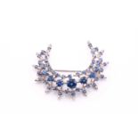 A sapphire and diamond crescent shape brooch, the round sapphires graduate from 1.7 – 6.0mm in