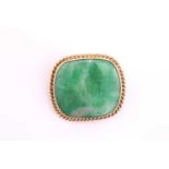 A cushion shape jade cabochon brooch, within a yellow precious metal ropetwist surround, pin