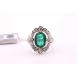 An emerald and diamond ring, the oval mixed cut emerald, 5.38ct, with a halo of sixteen round