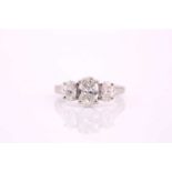 An oval cut diamond three stone ring consisting of a central oval cut diamond measuring 8.1 x 5.5