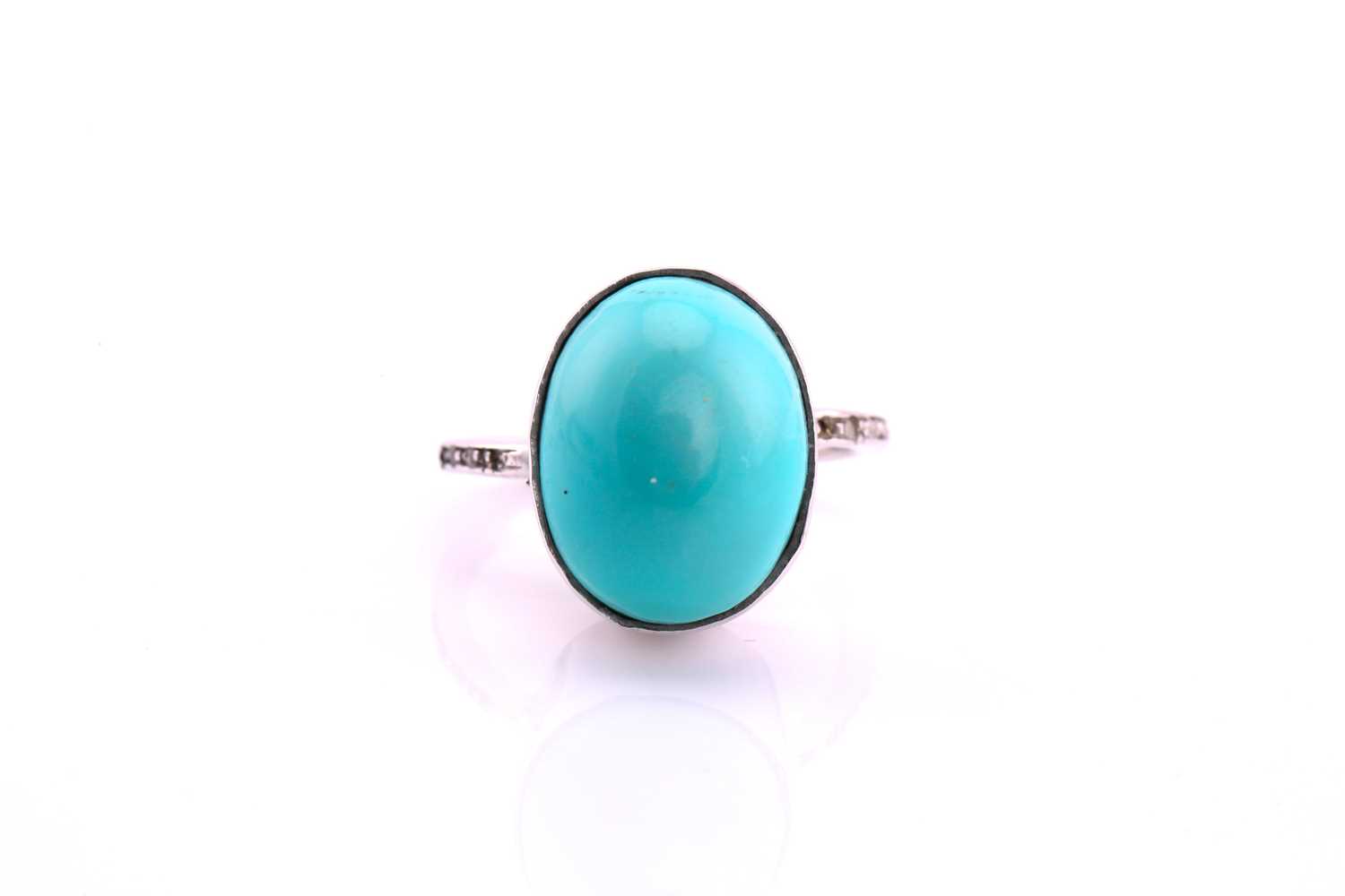 A turquoise and diamond ring, the oval cabochon turquoise, 17.4mm by 13.6mm set in white metal