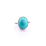 A turquoise and diamond ring, the oval cabochon turquoise, 17.4mm by 13.6mm set in white metal