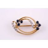 A sapphire and diamond brooch; the swirling hoop set with two, three stone sapphire trefoils and two