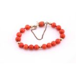 Red coral bead bracelet, averaging 8.5mm diameter, with yellow precious metal rondelle links, with