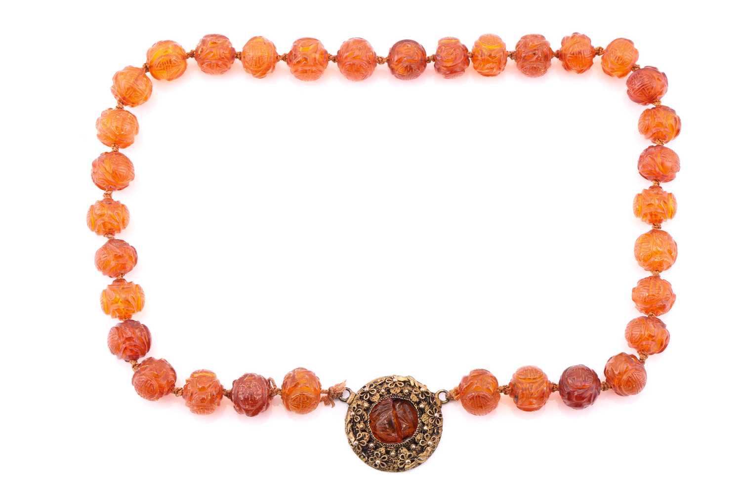 A single row carved amber bead necklace, each carved with 'Shou' medallions and foliage, gilt