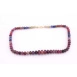A sapphire and ruby faceted bead necklace, the yellow, blue, pink and red graduated beads 14mm
