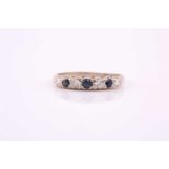 A seven stone half hoop sapphire and diamond ring; the circular cut sapphires and round brilliant