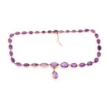 An amethyst riviere necklace, early 20th century, the graduated oval cut amethysts with a central