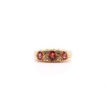 A seven-stone garnet and diamond half hoop ring; the three graduated oval cut garnets with four